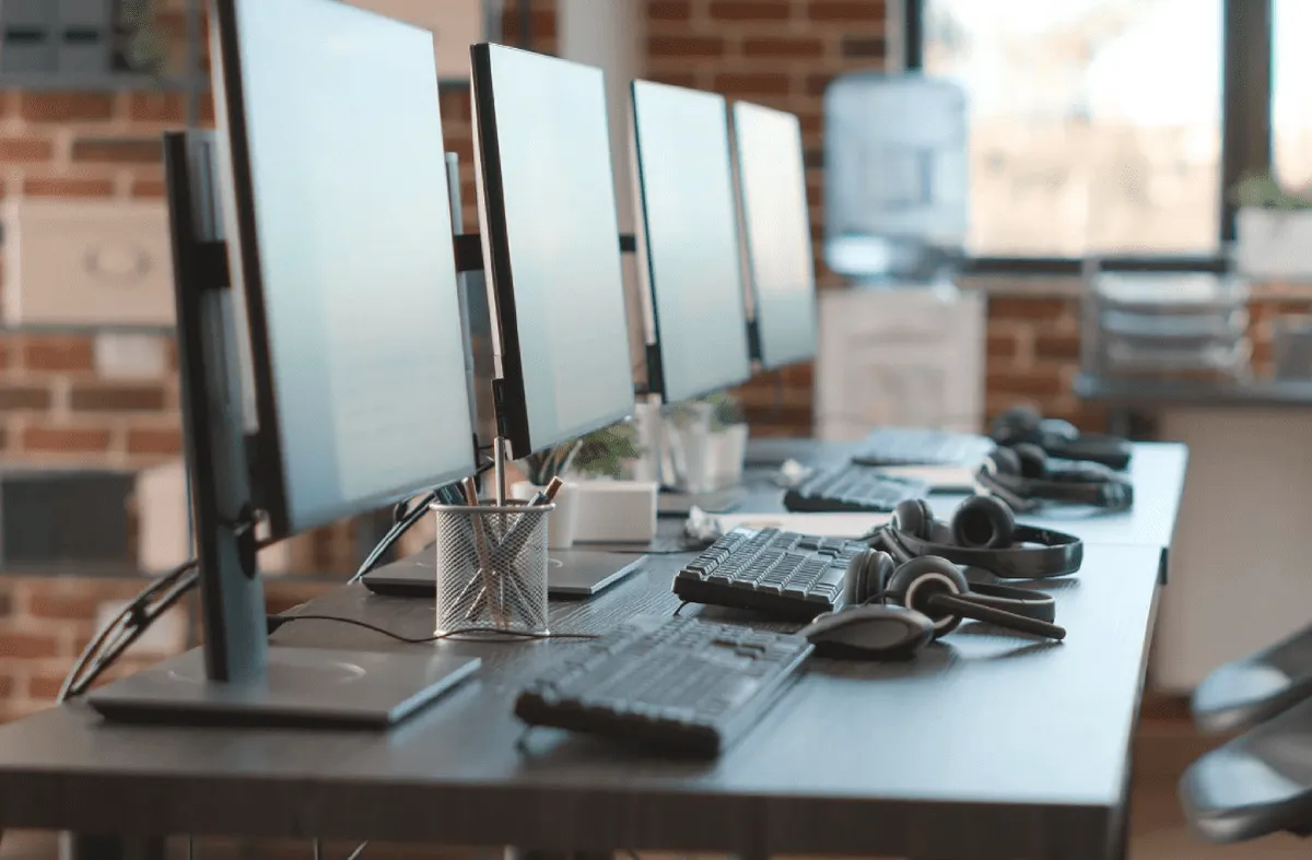 Aufgeräumte Arbeitsplätze mit Monitoren und Headsets